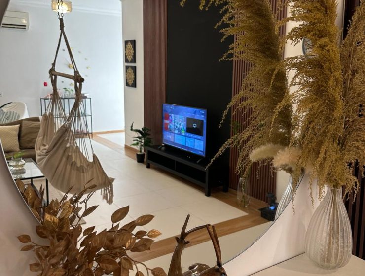 پذیرایی آپارتمان دوخوابه NC-02 با تلویزیون، مبل و صندلی آویز در مسقط، عمان